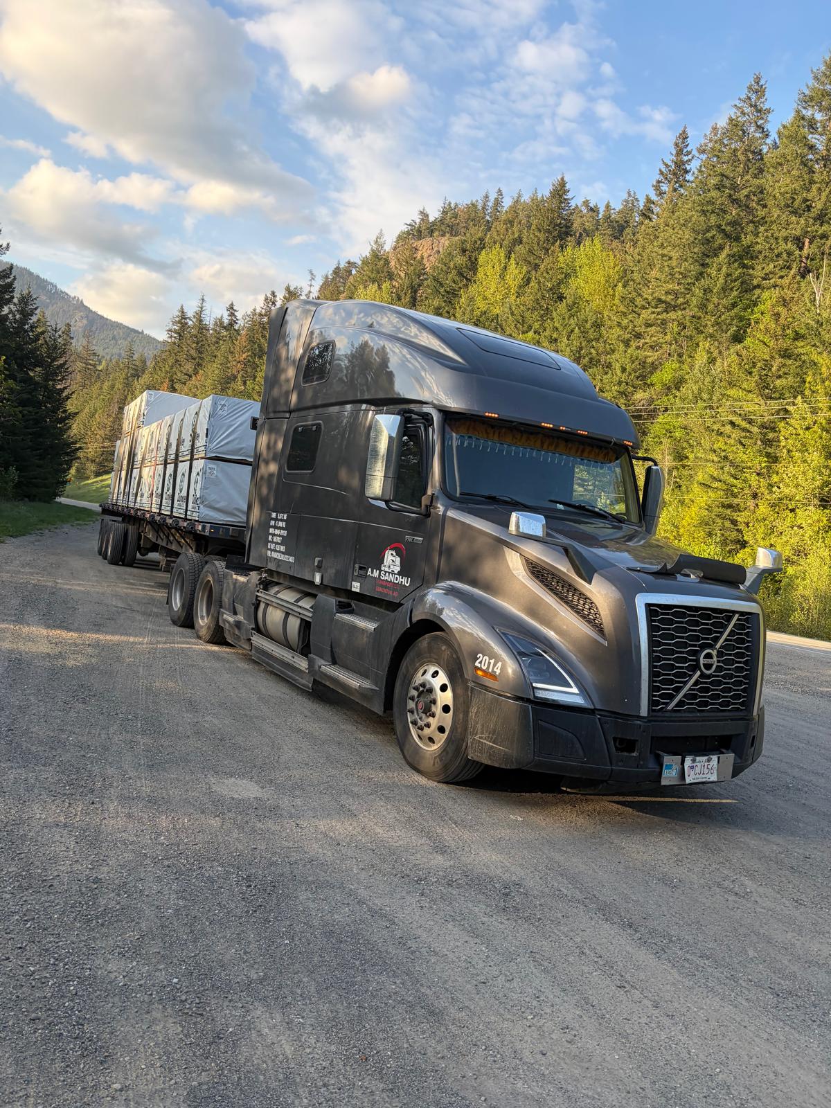 Volvo tractor with loaded flatbed in the mountains